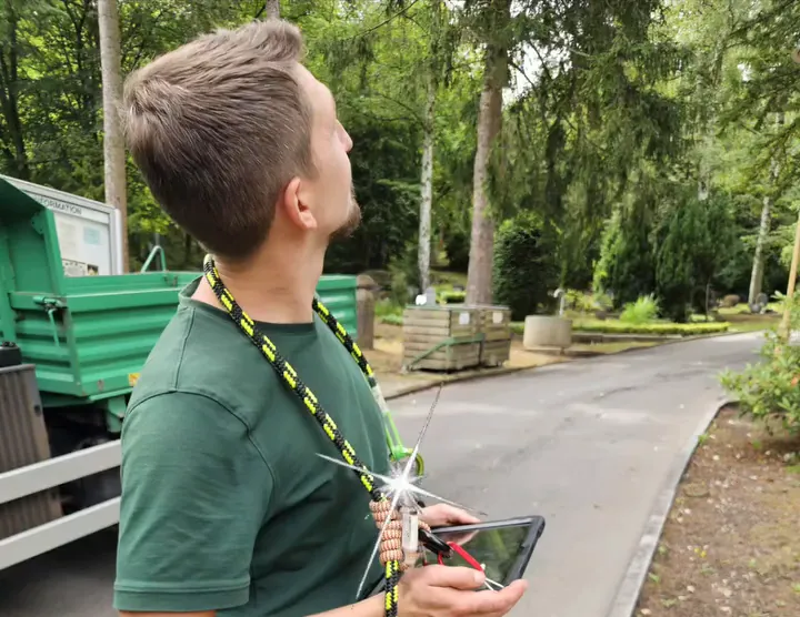 Baumkontrolle mit Tablet am Gurt, Kontrollweg im Park